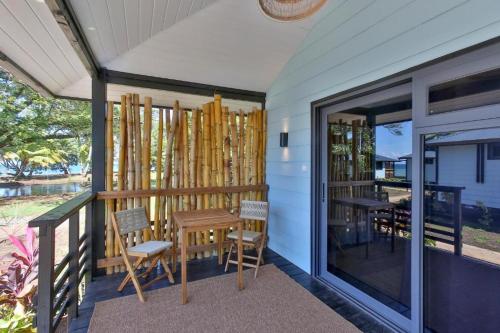 a house with a table and chairs on a porch at Sublime Tahiti Beach Retreat in Mataiea