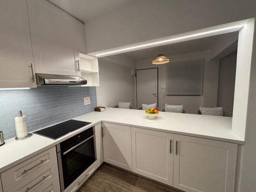 a kitchen with white cabinets and a counter top at Paros Relux in Kampos Paros