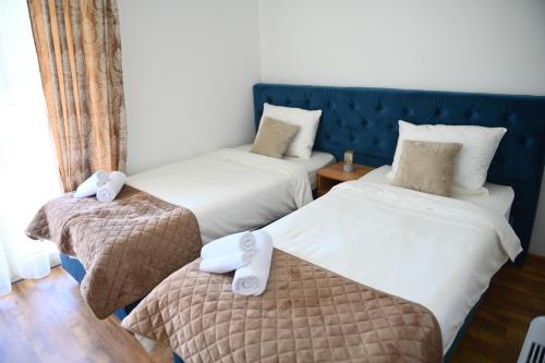 a bedroom with two beds with white sheets at Vila Mir in Banja Vrućica
