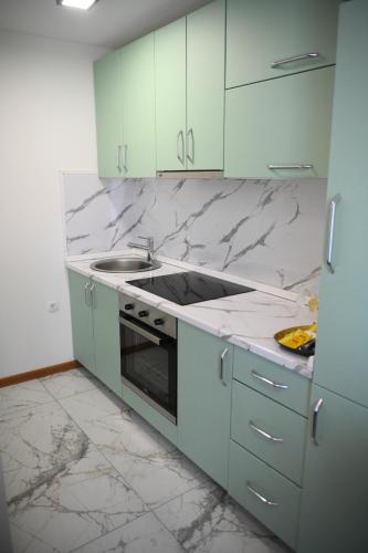 a kitchen with marble counter tops and a stove top oven at Vila Mir in Banja Vrućica