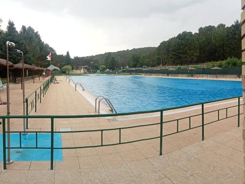 una grande piscina con ringhiera di metallo intorno di El descanso de las hadas a San Leonardo de Yagüe