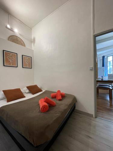 - une chambre avec 2 lits avec des oreillers orange dans l'établissement La Maquette - à 2 pas des Arènes, à Nîmes
