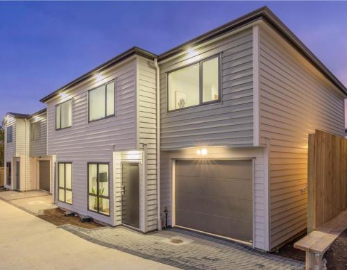 a house with a garage in front of it at 4 Bedroom holiday home at 99 in Auckland