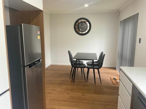 a kitchen with a table and chairs and a refrigerator at 4 Bedroom holiday home at 99 in Auckland