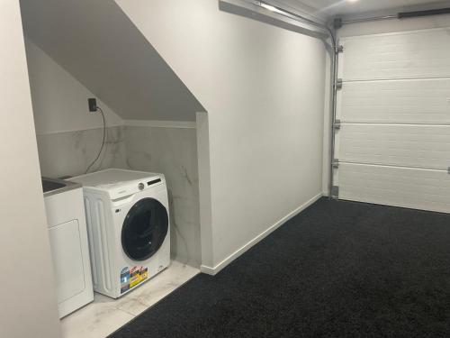 a laundry room with a washer and dryer at 4 Bedroom holiday home at 99 in Auckland