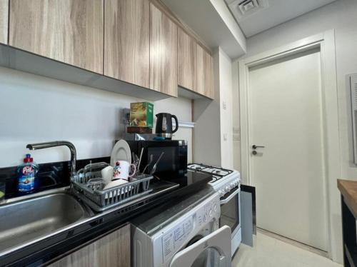 a kitchen with a sink and a dishwasher at Damac Golf vita in Dubai