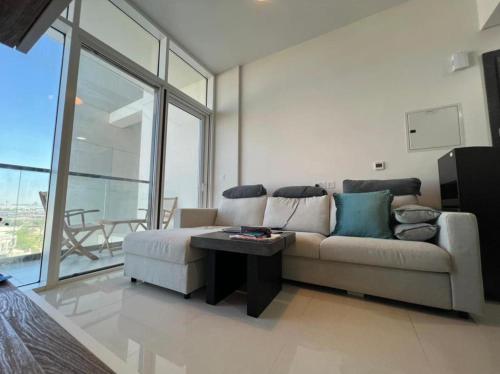 a living room with a couch and a table at Damac Golf vita in Dubai