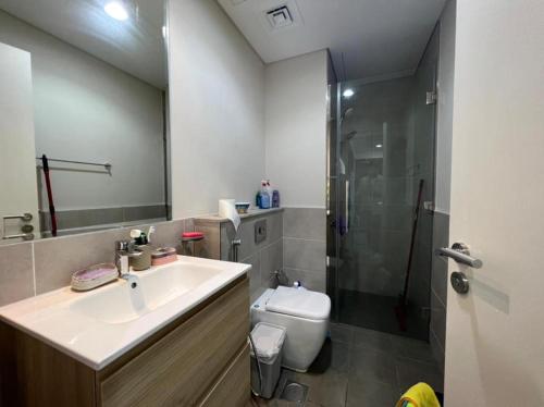 a bathroom with a sink and a shower and a toilet at Damac Golf vita in Dubai