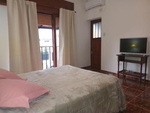 a bedroom with a bed and a flat screen tv at Amplia casa en planta alta en Av Mitre Parque Urquiza in Paraná
