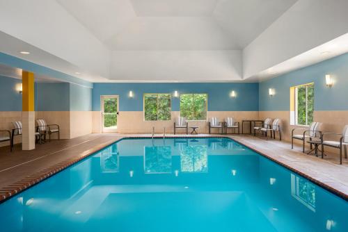 a pool in a hotel room with chairs and tables at Holiday Inn Express Hotel & Suites Fredericksburg by IHG in Fredericksburg