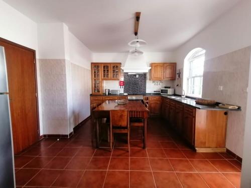a kitchen with wooden cabinets and a wooden table at Casas do Baleeiro - Vivenda do Terras in São Roque do Pico