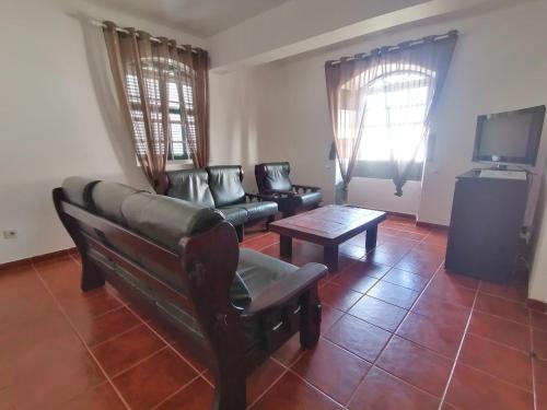 a living room with a couch and a tv at Casas do Baleeiro - Vivenda do Terras in São Roque do Pico