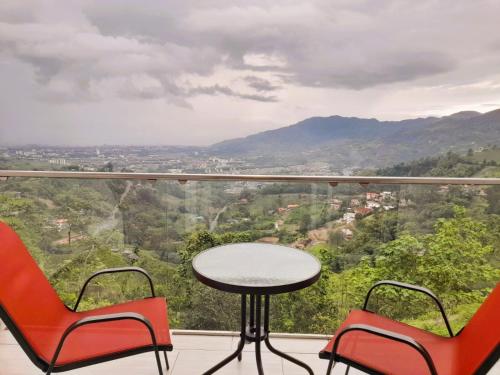 a table and two chairs on a balcony with a view at Hotel Entre Lomas in Santa Rosa de Cabal