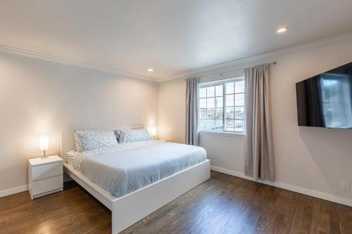 a bedroom with a bed and a flat screen tv at Luxurious 5 Bedroom Home with AC and EV Plug in Seattle
