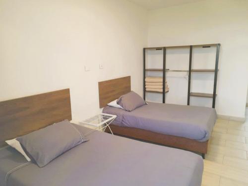 a bedroom with two beds and a book shelf at Hotel Entre Lomas in Santa Rosa de Cabal