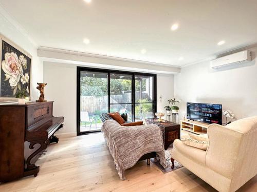 a living room with a couch and a piano at Luxury Glen Waverley Townhouse 4BR3BA Backyard in Glen Waverley