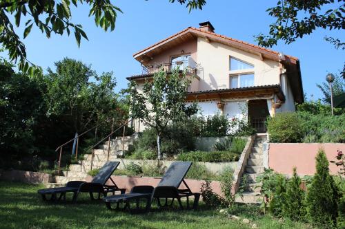 a group of chairs in front of a house at Къща за гости АВЛИГА in Varna City
