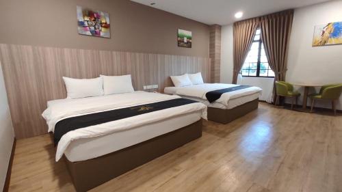 a hotel room with two beds and a table at Maple Boutique Hotel in Malacca