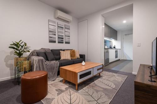 a living room with a couch and a coffee table at Footscray pool pleasant &Bright 2BR2BA apt in Melbourne