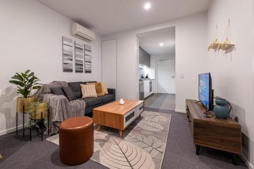 a living room with a couch and a tv at Footscray pool pleasant &Bright 2BR2BA apt in Melbourne
