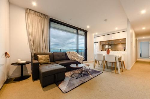 a living room with a couch and a table at Luxury living on top floors 3 Bedroom Mel CBD Pool in Melbourne