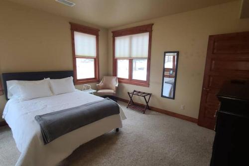 a bedroom with a bed and a chair and windows at Low Tax Luxe Mountain Getaway by Aspen in Carbondale