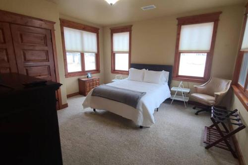 a bedroom with a bed and a chair and windows at Low Tax Luxe Mountain Getaway by Aspen in Carbondale