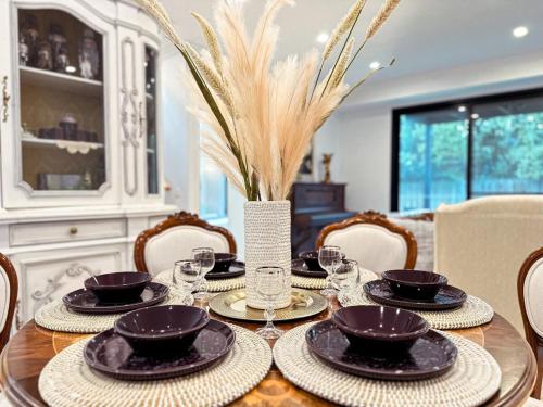 a dining room table with plates and glasses on it at Luxury Glen Waverley Townhouse 4BR3BA Backyard in Glen Waverley