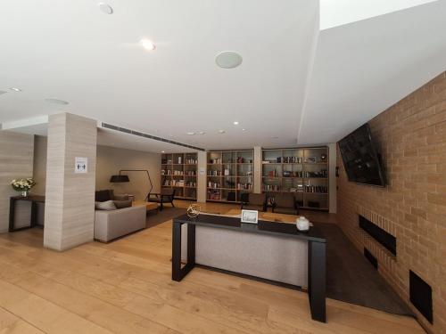 a large room with a brick wall and a desk at Brand new 2BR2BA Caulfield parkbalcony poolgym in Melbourne