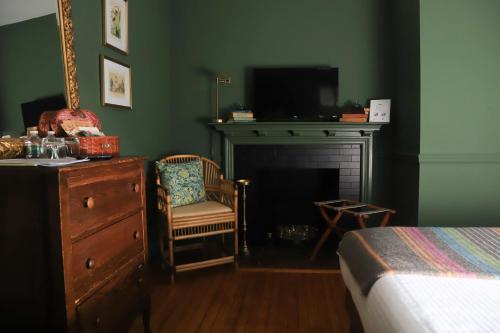 a bedroom with a bed and a dresser and a fireplace at Hartstone Inn in Camden