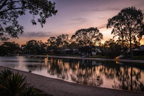 a river at sunset with ducks in the water at Lakefront 4 Br House At Patterson Lake Kayakbbq in Patterson Lakes