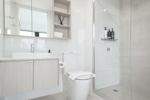 a white bathroom with a toilet and a shower at Stunning 2br Loft Maribyrnongfree Parkingbalcony in Maribyrnong