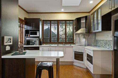 a kitchen with a white counter and a window at Garden Burees in Byron Bay