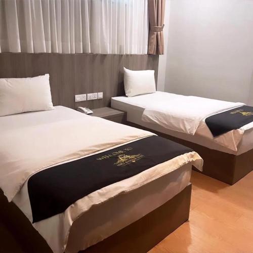 two beds sitting next to each other in a room at Maple Boutique Hotel in Malacca