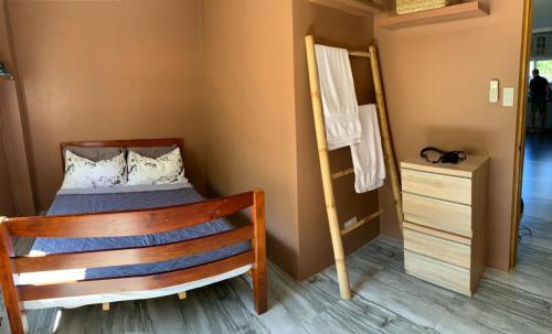 a small bedroom with a bed and a dresser at TLT Guesthouses - Dauin in Dauin