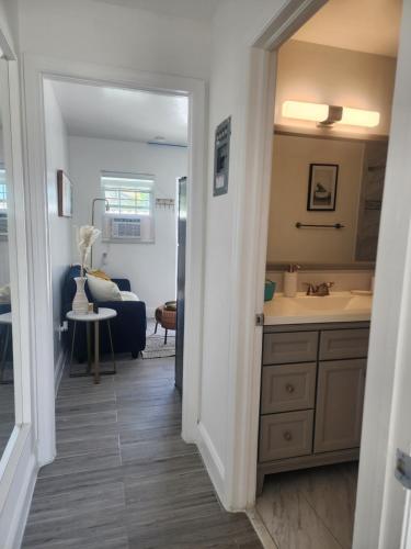 a bathroom with a sink and a vanity with a mirror at Cape Bungalow - Newly Renovated, Fully Equipped, Minutes from the Beach! in Cape Coral