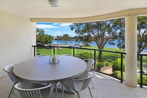 a table and chairs on a balcony with a view of the water at Spinnaker Quays in Mooloolaba