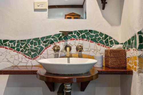 a bathroom with a sink and a mosaic wall at Garden Burees in Byron Bay