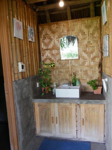 a bathroom with a sink and a window in a room at TLT Guesthouses - Dauin in Dauin