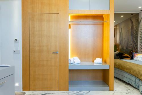 a room with a bed and a closet with towels at Ortigia Sitari suites in Siracusa