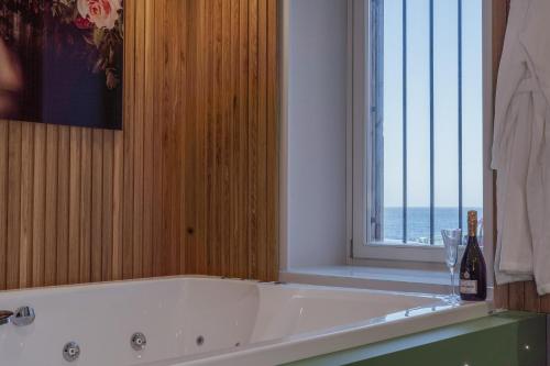 a bath tub in a bathroom with a window at Ortigia Sitari suites in Siracusa