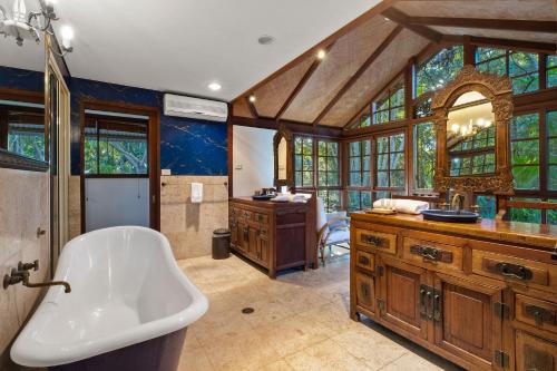 a large bathroom with a tub and a sink at Garden Burees in Byron Bay