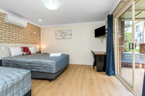 a bedroom with two beds and a television in it at Lismore Wilson Motel in Lismore