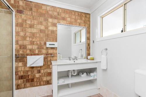 a bathroom with a sink and a mirror at Lismore Wilson Motel in Lismore