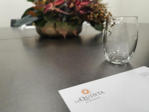 a wine glass sitting on top of a table with a card at La Quinta by Wyndham Parnell Auckland in Auckland