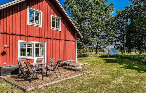 a red barn with chairs and a table on a deck at Awesome Home In Vislanda With Wifi in Vislanda