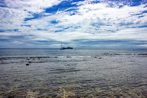 a boat is in the water on a beach at Heritage Park Hotel in Honiara