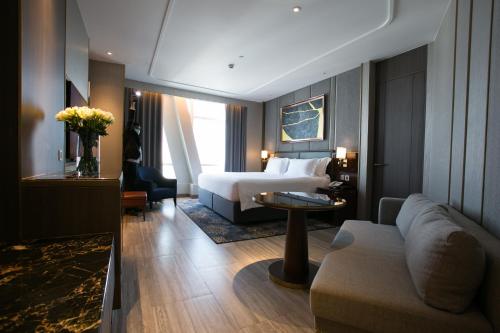 a hotel room with a bed and a couch at Centara Grand At CentralWorld in Bangkok