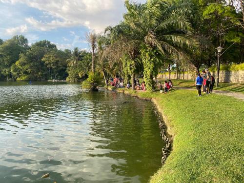 pessoas andando em torno de um lago em um parque em Tamu House Botani em Ipoh