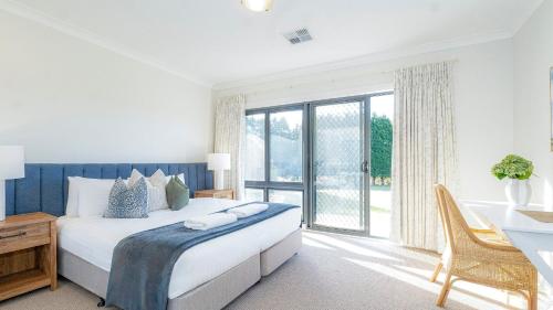 a bedroom with a bed and a desk and a window at Silos in East Kangaloon